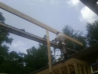 Carpenter setting a ridge beam over a new addition frame — Ice Dam Removal by Roofing Brothers in Gallipolis