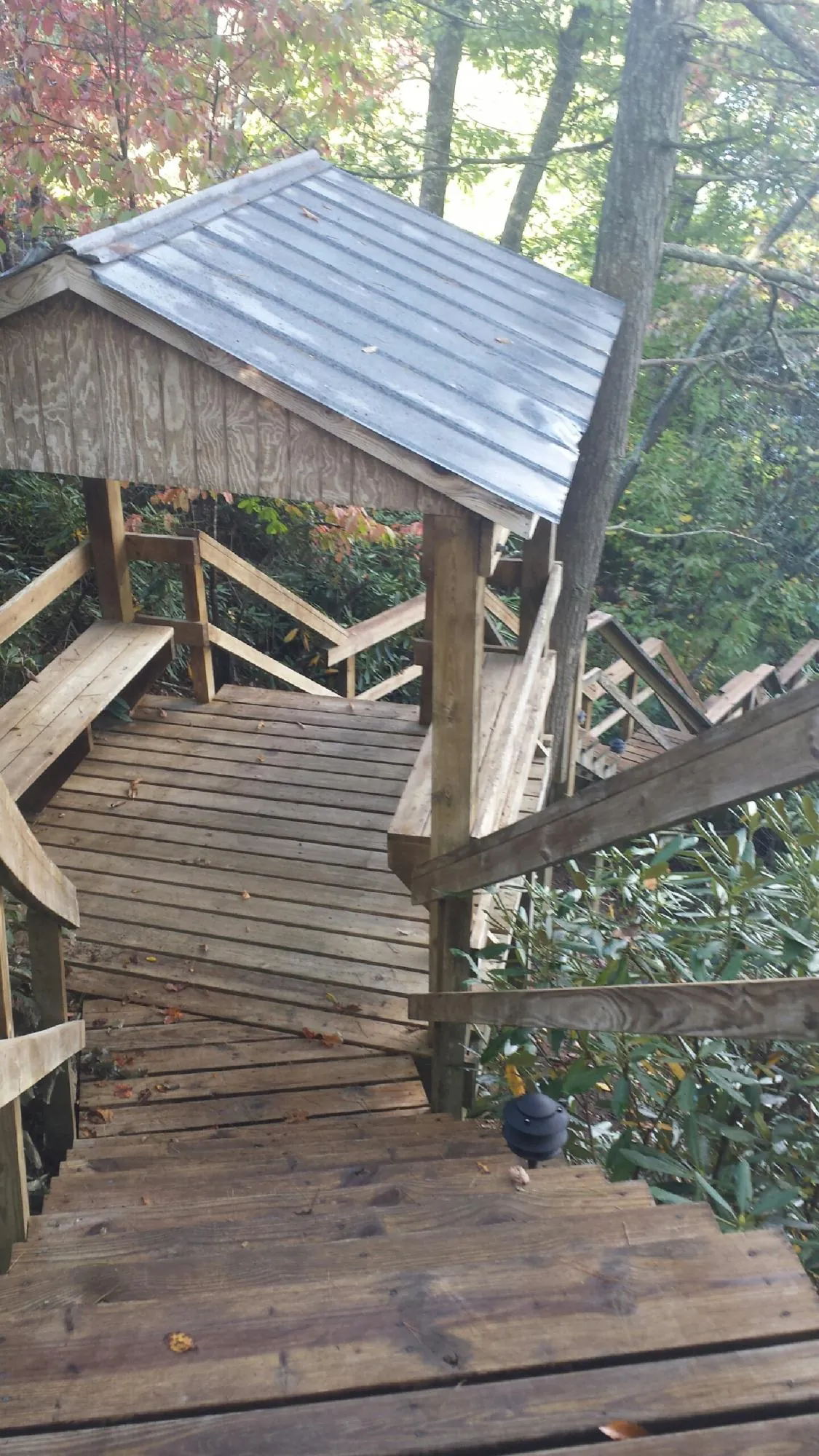 Metal roofed shelter over wooden steps on a wooded walkway — Skylight Repair & Installation work by our crew in Gallipolis