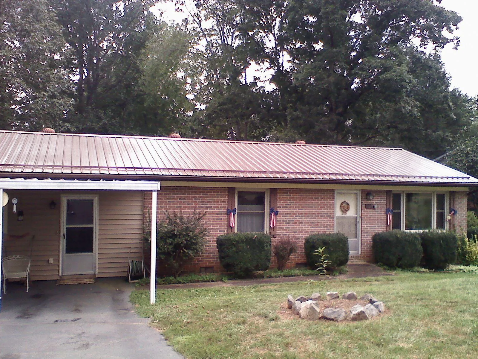 Bronze metal roof and carport on a brick ranch home — Roof Repair work by our crew in Gallipolis